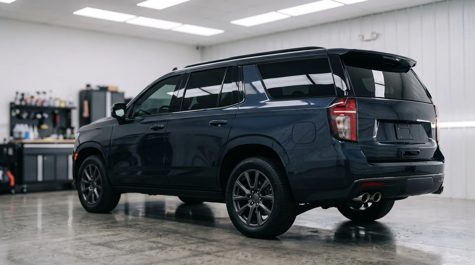Full-size SUV in a clean detailing studio showing dark ceramic tint on the rear side glass and cargo-area windows, window tint for SUVs in Auburn, AL