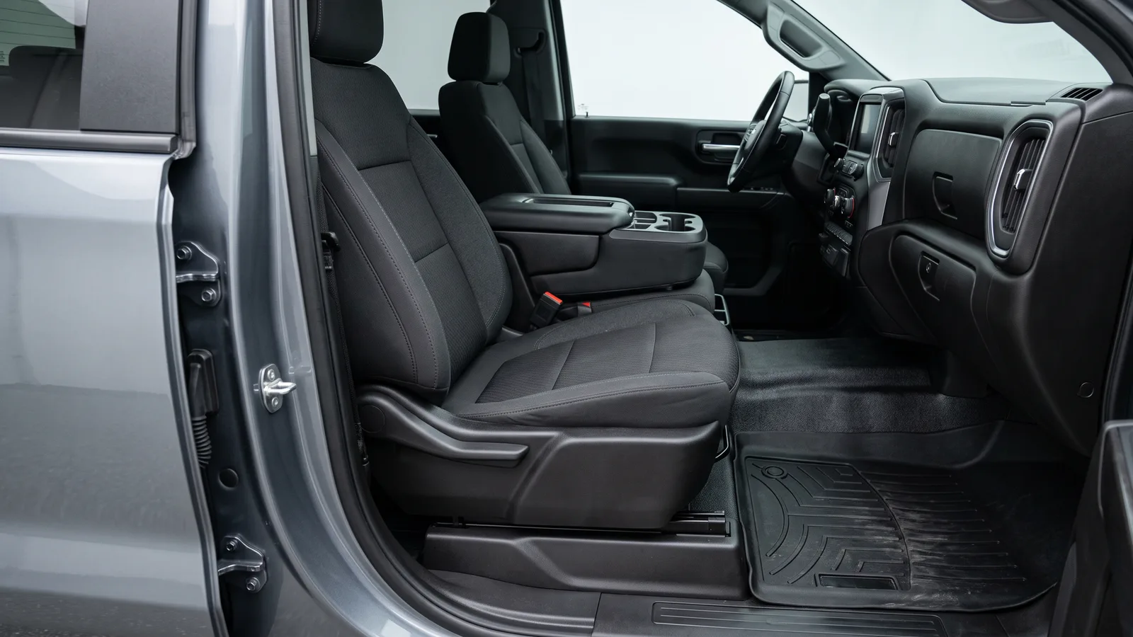 Clean crew-cab pickup truck interior with shampooed cloth seats and scrubbed rubber all-weather floor mats after a truck interior detail