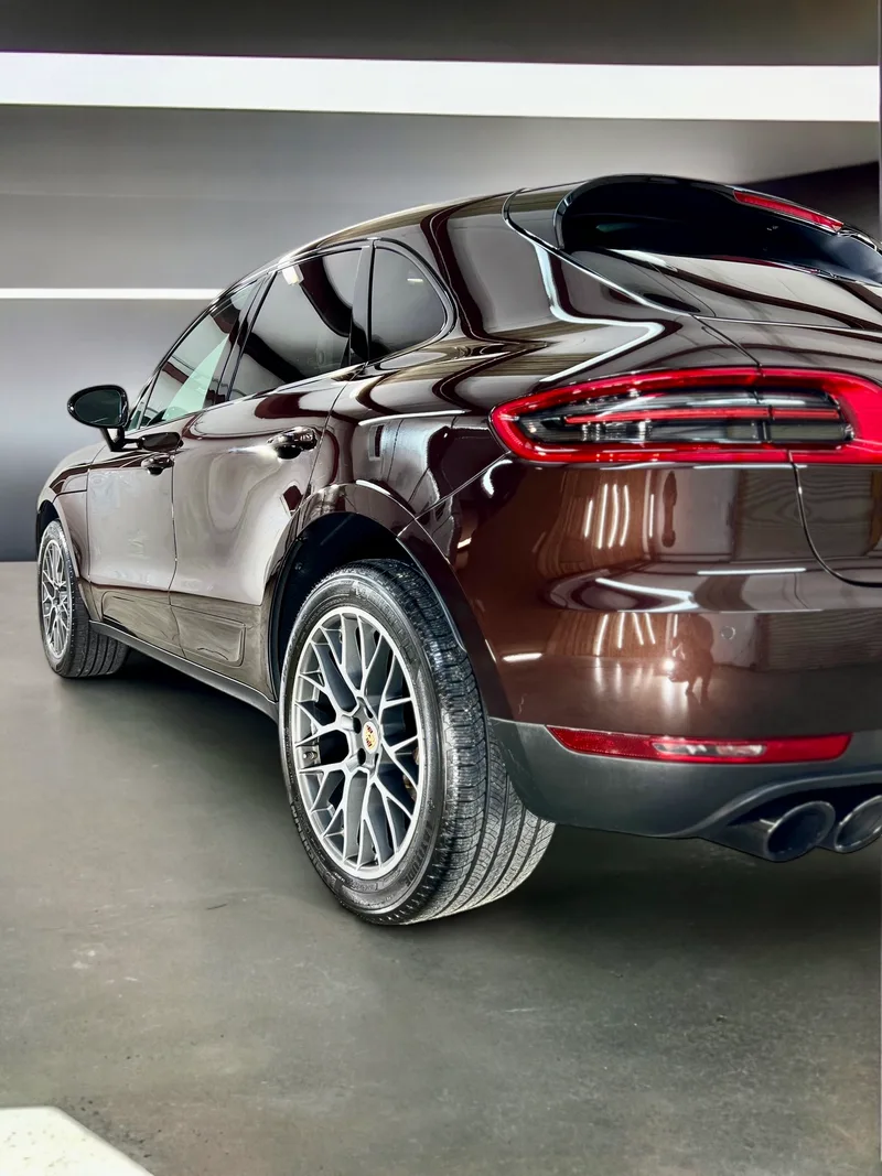 Brown Porsche Macan rear quarter in shop