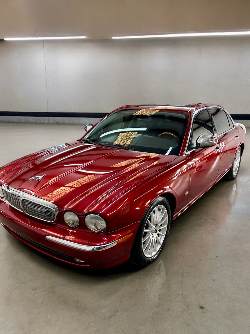 Red Jaguar XJ front quarter in shop