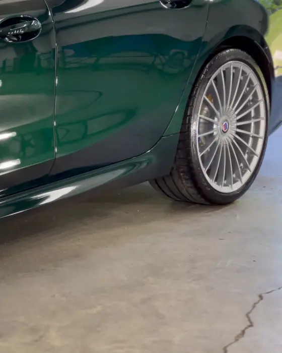 A green BMW Alpina B8 Gran Coupe side and wheel after ceramic coating