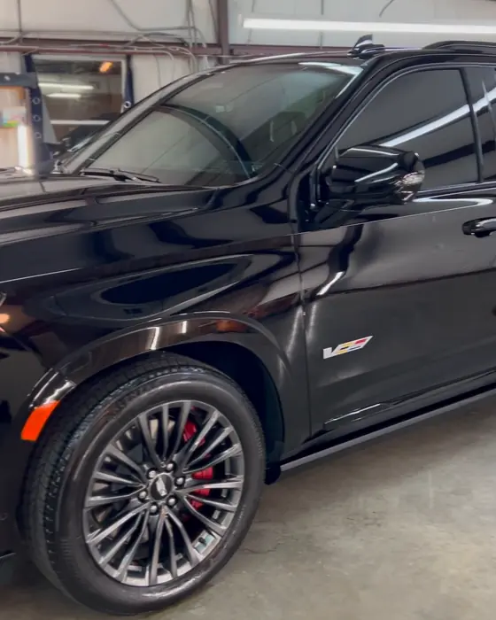 A black Cadillac Escalade-V side and wheel in our shop after ceramic coating