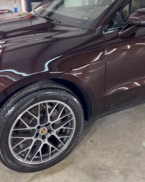 A burgundy Porsche Macan in our shop after ceramic coating